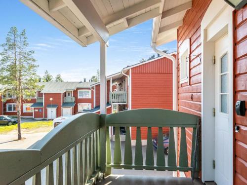 un porche con un riel verde y una casa roja en Holiday Home Rautulampi g 20 by Interhome, en Saariselkä