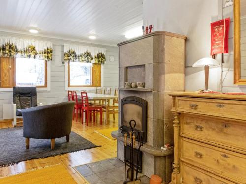 a living room with a fireplace and a dining room at Holiday Home Käpälämäki by Interhome in Raanujärvi
