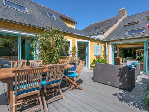 eine Holzterrasse mit einem Holztisch und Stühlen in der Unterkunft Holiday Home La Demeure Ty Ar Bleiz by Interhome in Sarzeau