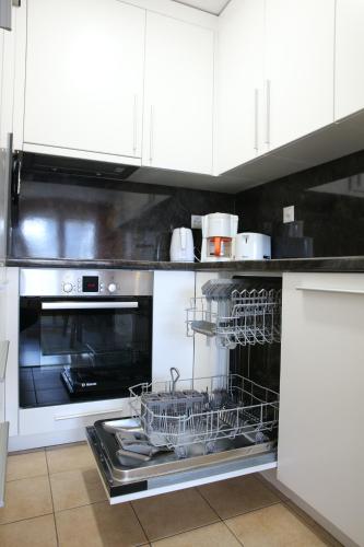 a kitchen with an oven with dishes in it at Monte Rosa Apartments Täsch in Täsch