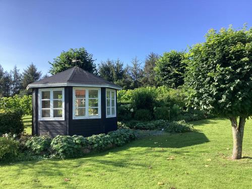 a small cabin in the middle of a garden at Ferielejlighed til 2 personer in Ebeltoft