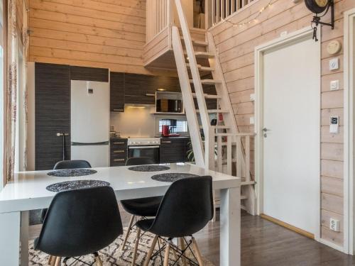 a kitchen with a white table and black chairs at Holiday Home Peuhu a4 by Interhome in Oulunsalo