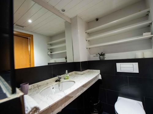 a bathroom with a sink and a mirror at MEQUEDO CALDEREROS 25 in Alcañiz