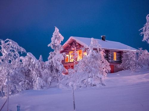 a house covered in snow with lights on it at Holiday Home Uuvana by Interhome in Saariselka