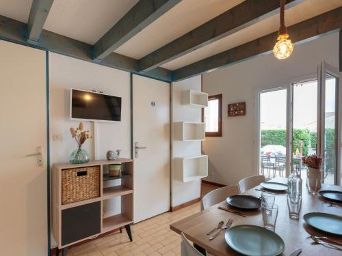 une salle à manger avec une table et une télévision dans l'établissement Holiday Home Les Charmilles-12 by Interhome, aux Mathes