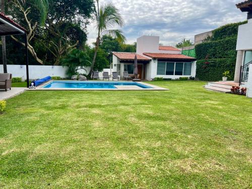 a yard with a swimming pool and a house at VILLA AMATE DORADO in Xochitepec