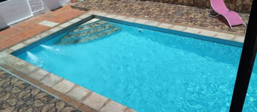 una piscina con agua azul y rocas en Hotel Villa Elisa en Villa Elisa