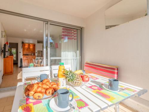 - une table avec une assiette de pain et des fruits dans l'établissement Apartment Ipanema by Interhome, à La Grande Motte