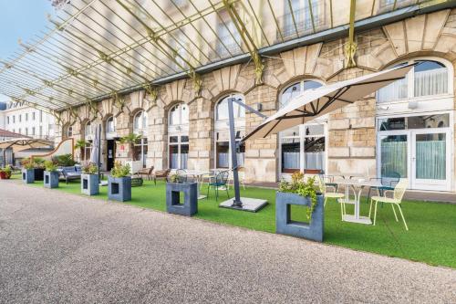 a building with tables and chairs and a glass ceiling at Mercure Lyon Centre Château Perrache in Lyon
