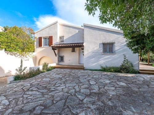 a white house with a stone driveway at Holiday Home Turriccioli by Interhome in Porto-Vecchio