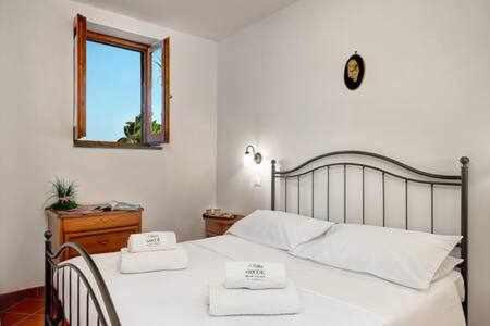 una camera da letto con un letto con due asciugamani bianchi di Ginestra beach suite a Massa Lubrense