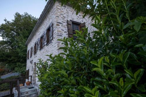 an old stone building with windows and a bush at Archontiko Michael Pelion in Vizitsa