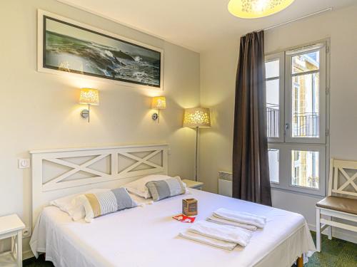 een slaapkamer met een wit bed en handdoeken bij Apartment Le Château de Kergonano-7 by Interhome in Baden