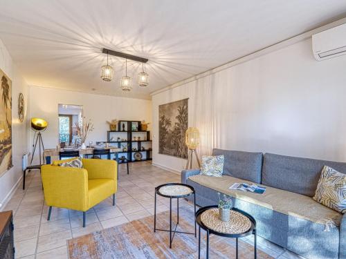 un salon avec un canapé et une chaise jaune dans l'établissement Apartment Le Capricorne by Interhome, à Saint-Raphaël