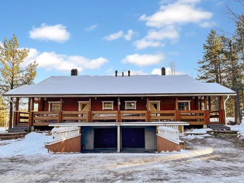 a large wooden house with a snow covered roof at Holiday Home Jytilevi a by Interhome in Sirkka