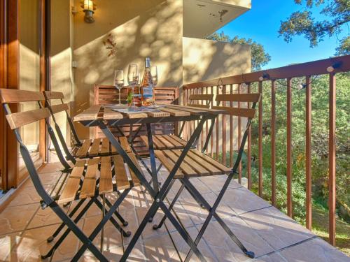 une table et des chaises en bois sur un balcon dans l'établissement Apartment Le Capricorne by Interhome, à Saint-Raphaël