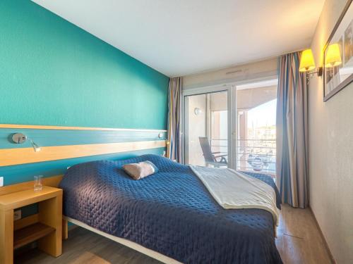 une chambre avec un lit avec un mur bleu dans l'établissement Apartment Cap Hermes-5 by Interhome, à Fréjus