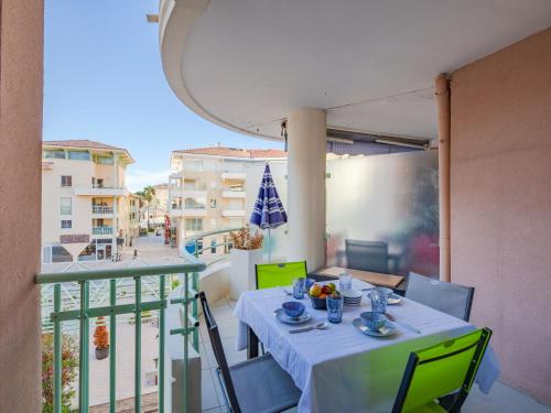 - une table sur un balcon avec vue sur un bâtiment dans l'établissement Apartment Quartier Latin-13 by Interhome, à Fréjus