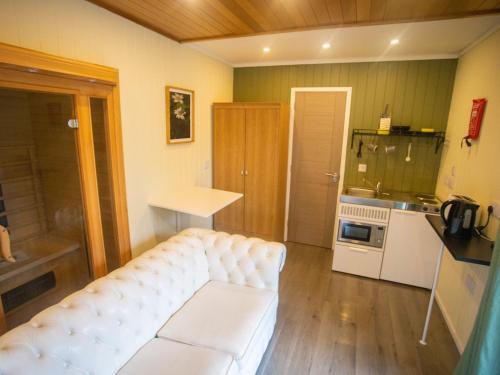uma sala de estar com um sofá branco e uma cozinha em Chalet Nessie 1 by Interhome em Drumnadrochit