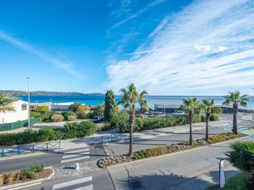une rue avec des palmiers et l'océan en arrière-plan dans l'établissement Apartment La Croix du Sud-28 by Interhome, à Cavalaire-sur-Mer