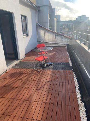 una sedia rossa seduta su un ponte di un edificio di Pôr do Sol a Bragança