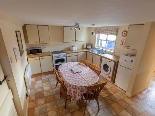 a kitchen with a table and chairs and a kitchen with a sink at Holiday Home Lodge Road-2 by Interhome in Inverness