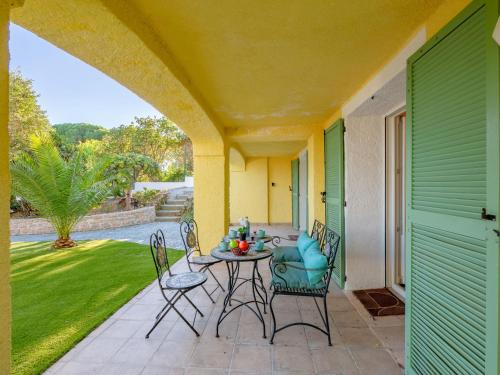 un patio avec une table et des chaises sur un porche dans l'établissement Holiday Home La Scarlett 1 by Interhome, aux Issambres