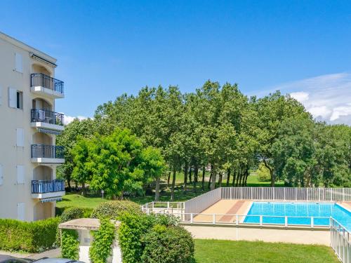 een appartementencomplex met een zwembad en bomen bij Apartment Parc de Pontaillac-30 by Interhome in Vaux-sur-Mer