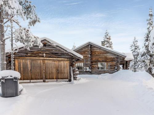 una cabaña de madera en la nieve con garaje en Holiday Home Kultarinne by Interhome, en Saariselkä