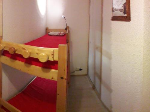 - une chambre avec des lits superposés et une couverture rouge dans l'établissement **Studio Cabine pour 4 pers. - Confort, Proximité Commerces/Télécabine, Animaux Acceptés** - FR-1-263-5, à Valloire