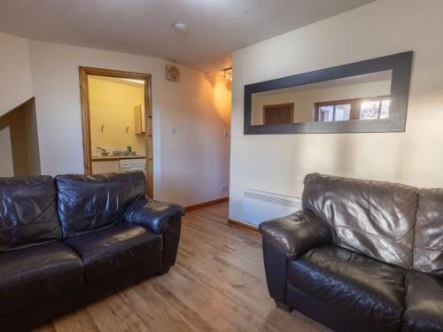 a living room with a leather couch and a mirror at Apartment Miller Apartment by Interhome in Inverness
