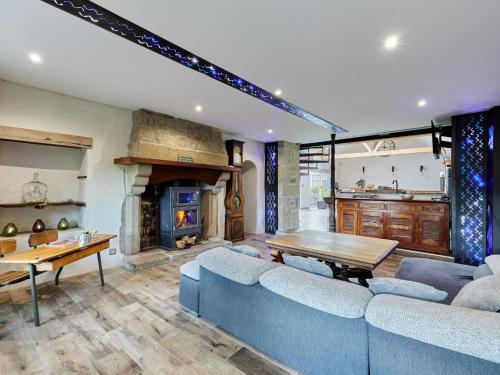 un salon avec un canapé bleu et une cheminée dans l'établissement Holiday Home Au coin des 3 feux by Interhome, à Réville