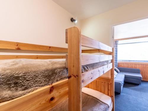 sypialnia z 2 łóżkami piętrowymi i kanapą w obiekcie Studio Home Club - Lavachet-12 by Interhome w mieście Tignes