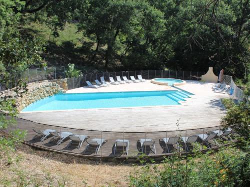 a large swimming pool with chairs around it at Holiday Home Les Grenaches by Interhome in Draguignan