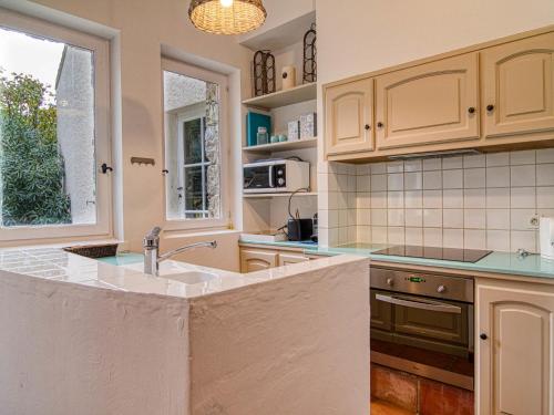 une cuisine avec des armoires blanches et un évier dans l'établissement Holiday Home Les Grenaches by Interhome, à Draguignan