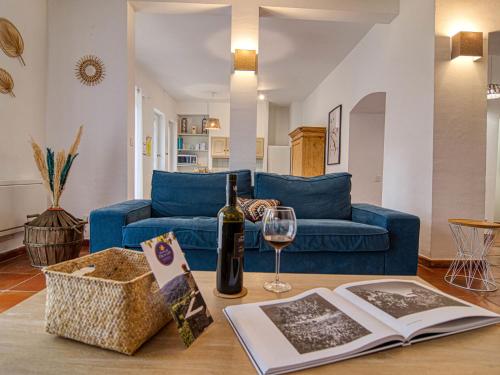 Sala de estar con sofá azul y copa de vino en Holiday Home Les Grenaches by Interhome, en Draguignan