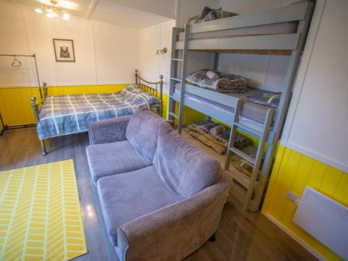 uma sala de estar com um sofá e beliches em Chalet Dougie's by Interhome em Drumnadrochit