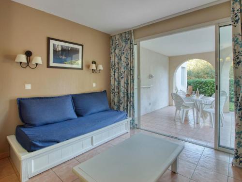 un salon avec un canapé bleu et une table dans l'établissement Apartment Les Rivages de Coudoulière-32 by Interhome, à Six-Fours-les-Plages