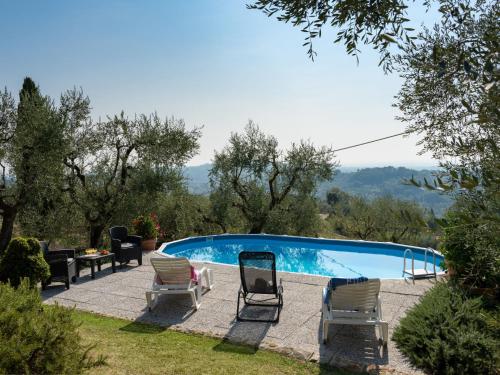 una piscina con dos sillas y una mesa en Apartment Chantal by Interhome, en Capannori