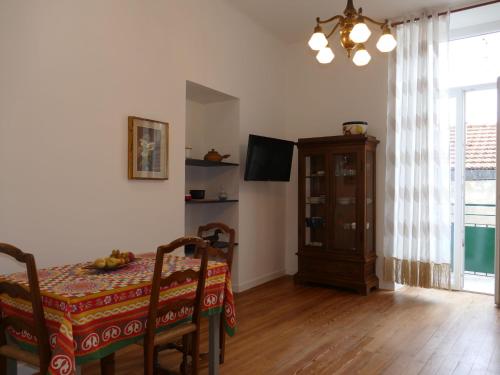 a dining room with a table and chairs and a television at Apartment Fiori e Canzoni by Interhome in Sanremo