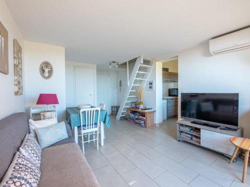 un salon avec un canapé et une télévision à écran plat dans l'établissement Apartment Les Jardins d'Amaryllis-9 by Interhome, à Cavalaire-sur-Mer