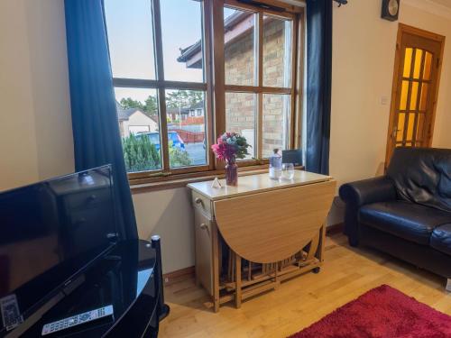 sala de estar con mesa y sofá en Apartment Towerhill Apartment by Interhome en Inverness