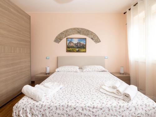 1 dormitorio con 1 cama con toallas en Apartment La Corleta-1 by Interhome, en Ovaro