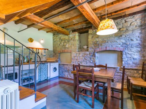 cocina con mesa de madera y pared de piedra en Holiday Home Al Volo del Nibbio-2 by Interhome, en Marradi