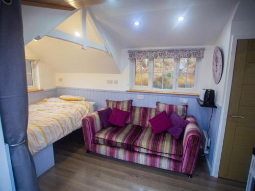 a bedroom with a bed and a couch and a bed at Chalet Affric 3 by Interhome in Drumnadrochit