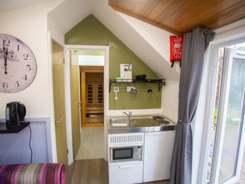 una pequeña cocina con fregadero y reloj en Chalet Affric 3 by Interhome, en Drumnadrochit