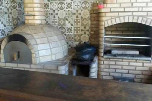a kitchen with a brick oven with a stove at Casa completa + área gourmet in Búzios