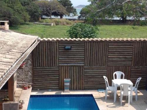 um pátio com uma mesa e cadeiras e uma piscina em Casa completa + área gourmet em Búzios