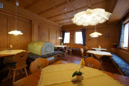 a dining room with tables and chairs and a chandelier at Residence Baita Antlia in Arabba