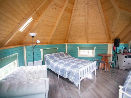 a bedroom with a bed and a couch in a room at Chalet Glen by Interhome in Drumnadrochit